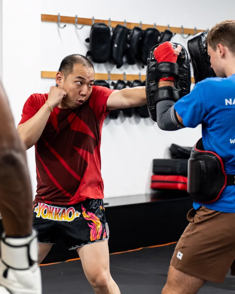 Adolphus Li working pads during a beginner Muay Thai class at Logic Philadelphia