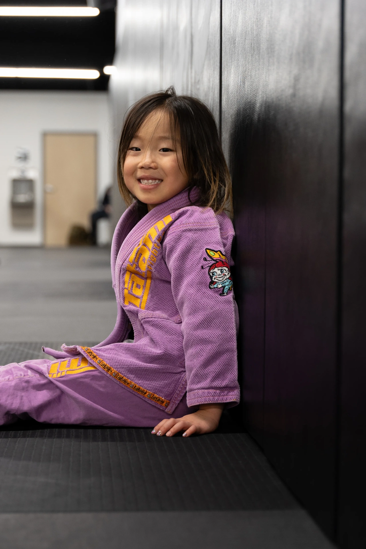 Young girl in purple gi smiling at Logic Jiu Jitsu Philadelphia