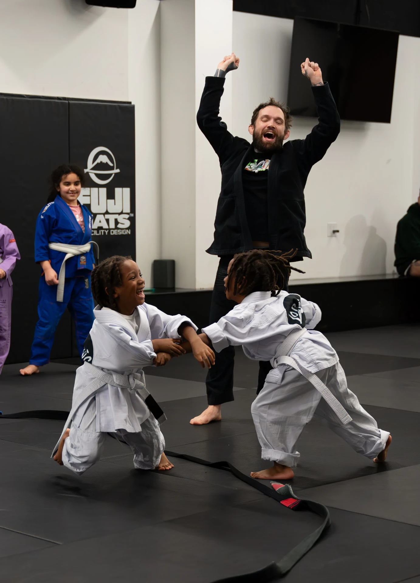 Kids practicing jiu jitsu with smiles during supervised sparring at Logic Jiu Jitsu Philadelphia