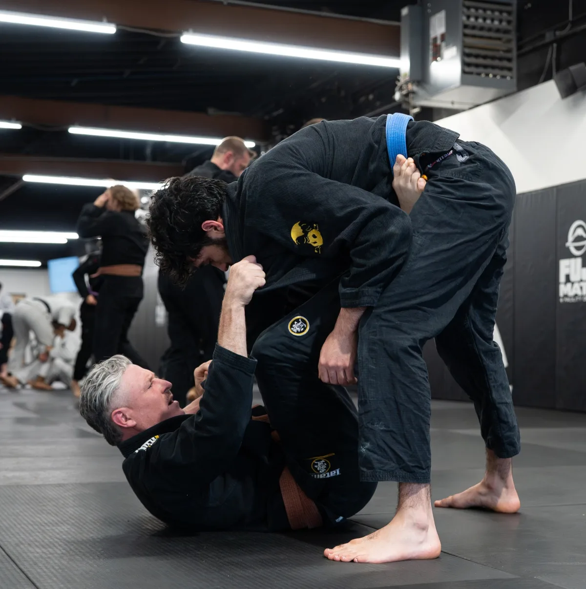 Adult brown belt in his 50s training live with a younger blue belt at Logic Jiu Jitsu Philadelphia