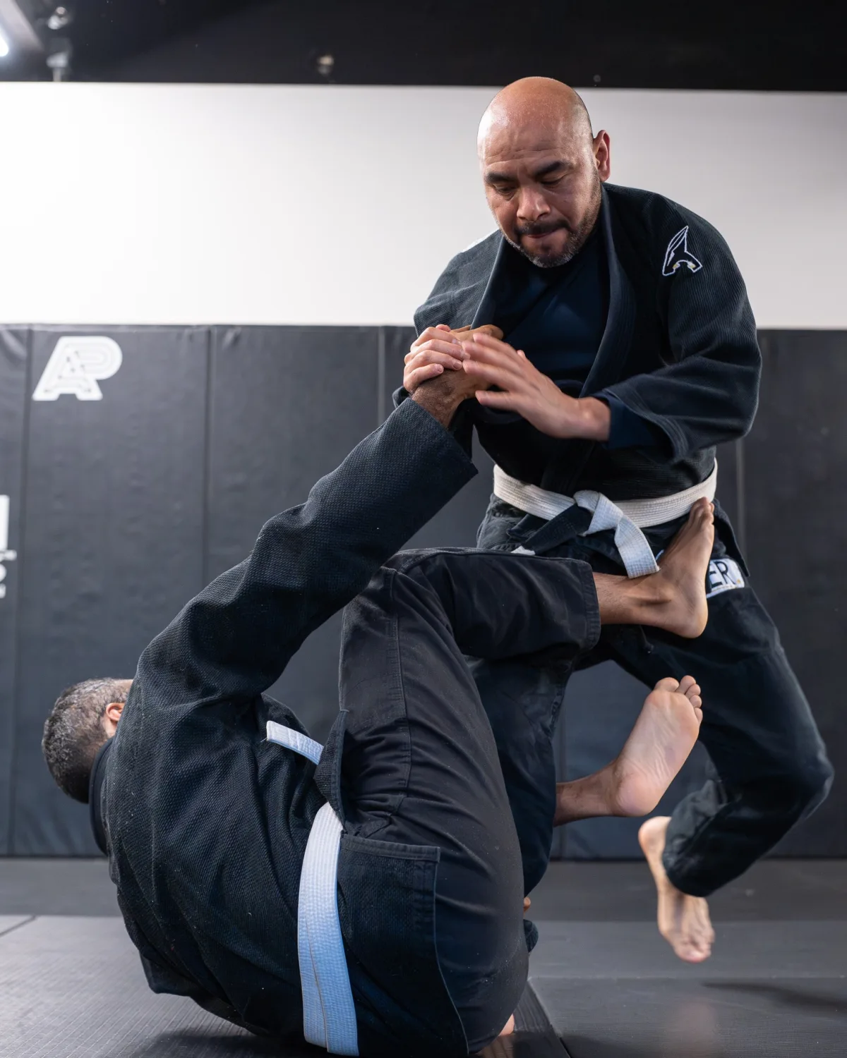 An adult white belt in his 40s training during a beginner Brazilian Jiu Jitsu class at Logic Philadelphia
